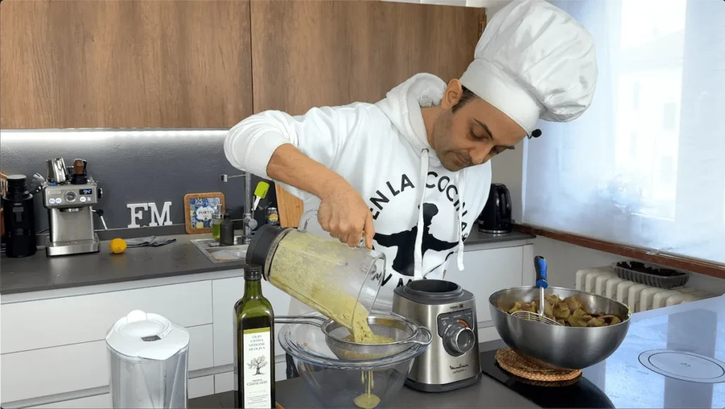 Colar la crema de alcachofas con un colador chinoise