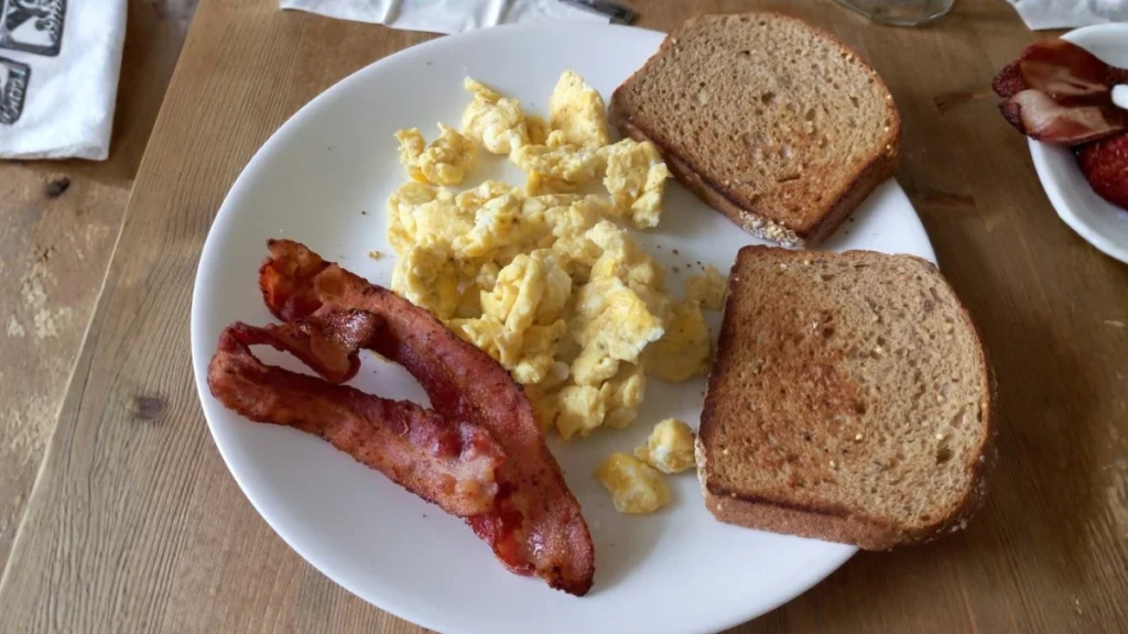 Huevos revueltos con tocino crujiente clasico desayuno americano