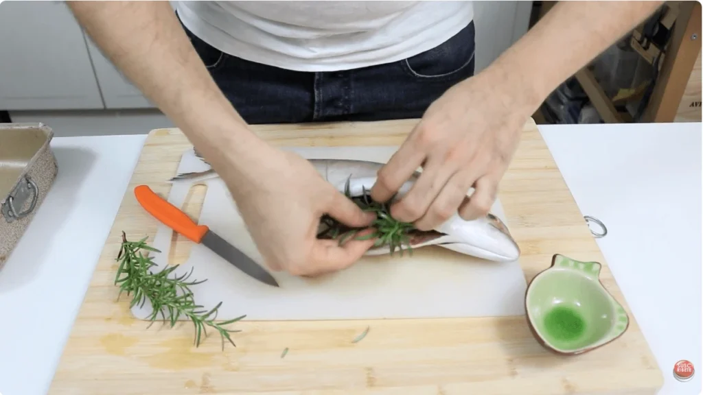rellenar la barriga del pescado con ajo y romero