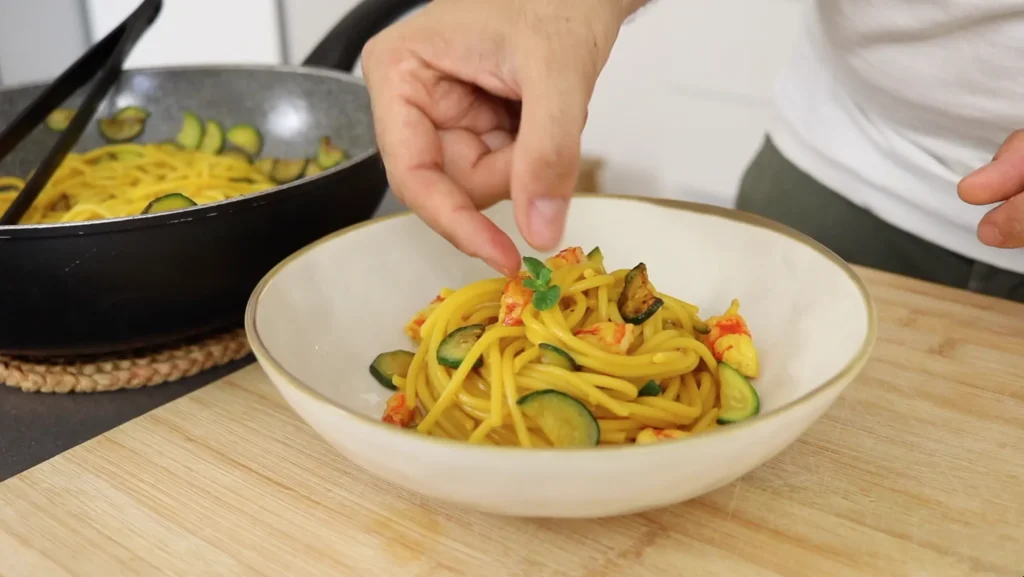 decorar pasta de gambas y calabacín con hojas de menta