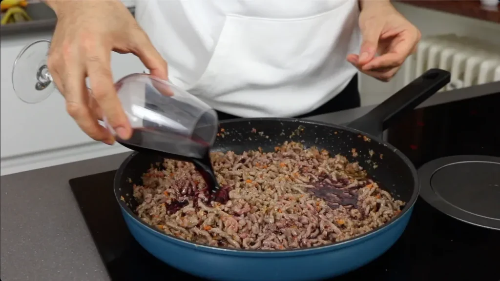 vertemos el vino tinto seco dentro la boloñesa